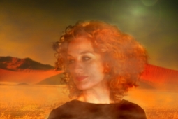 Morning fog in the desert. In foreground the portrait of a red haired woman with wonderful curls
